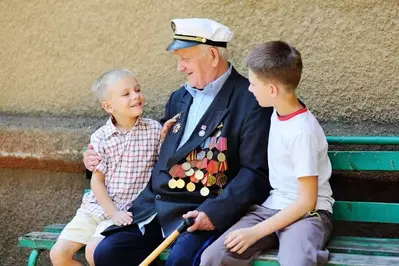 Veteran sitting on bench with children