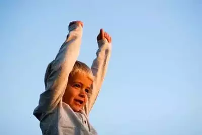 happy child raising arms in the air