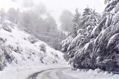 snow covered road winding through the mountains