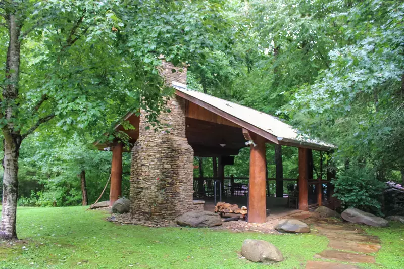 Down The Creek outdoor fireplace and covered seating area next to the river