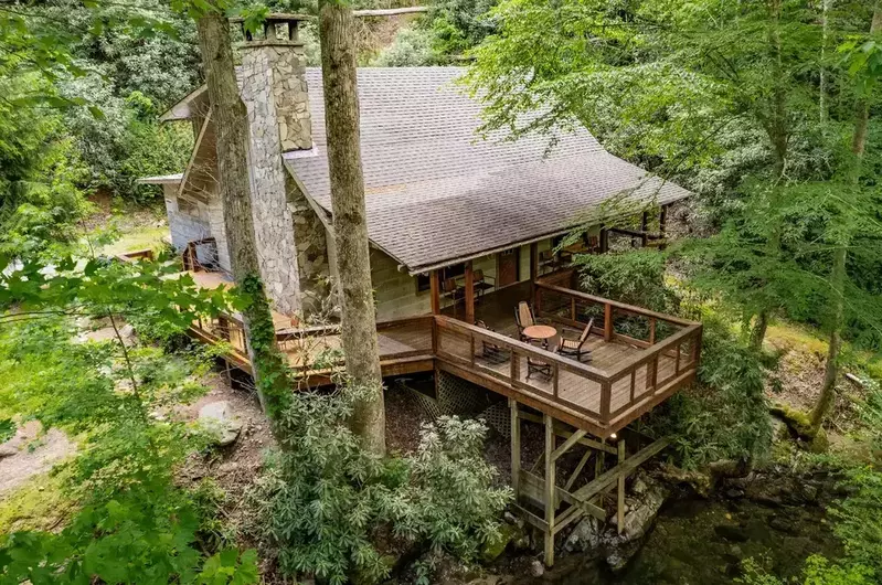 exterior of Up The Creek cabin surrounded by woods next to stream